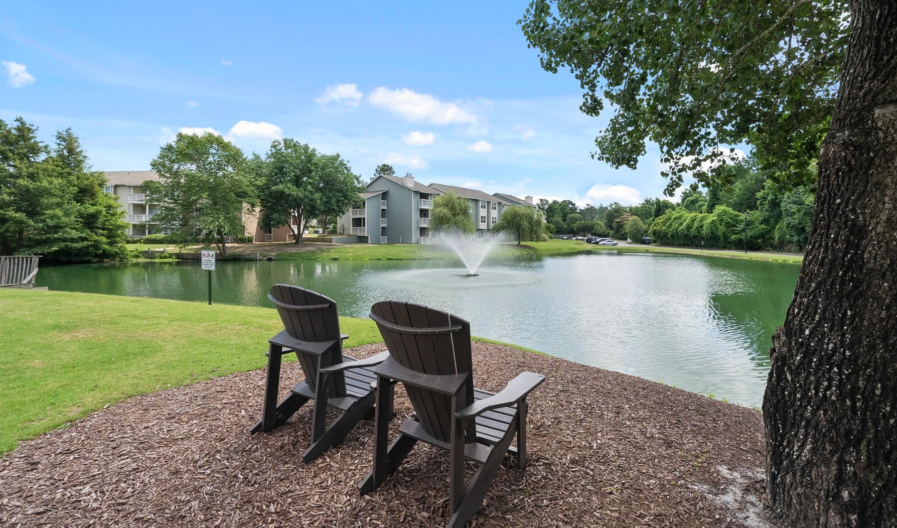 chairs and a fountain by a pond