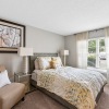 bedroom with a large window and a chair in the corner