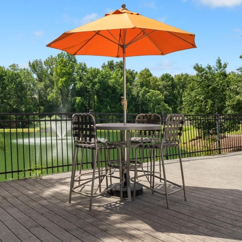 Relax and unwind poolside a patio with tables and chairs and umbrellas